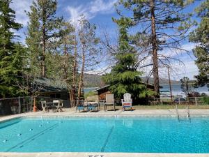 a swimming pool with two chairs and a house at Sunrise Lakefront Family Cabin by Big Bear Vacations in Big Bear Lake