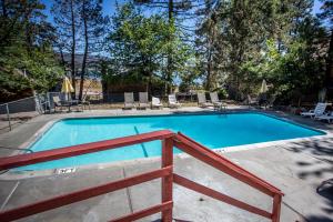 a swimming pool with a wooden fence around it at Lakefront Family Cabin by Big Bear Vacations in Big Bear Lake