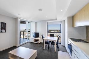 iStay Precinct Adelaide في أديلايد: مطبخ مفتوح وغرفة طعام مع طاولة وكراسي