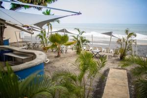 una playa con sillas y sombrillas y el océano en Tower Suite Hotel Coronado en Playa Coronado