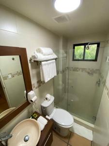 y baño con ducha, aseo y lavamanos. en Tower Suite Hotel Coronado en Playa Coronado