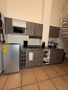 a kitchen with a stainless steel refrigerator and cabinets at Tower Suite Hotel Coronado in Playa Coronado