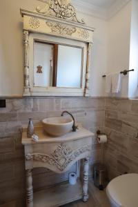 a bathroom with a sink and a mirror on the wall at Tas Bahce Hotel Cunda in Ayvalık
