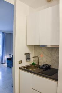 een keuken met witte kasten en een wastafel bij Apt.124 - Beautiful apartment on the lake in Porto Ceresio