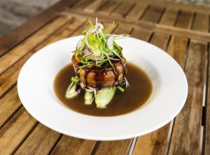 a white plate with a dish of food on a table at The Rising Sun Hotel in Auburn