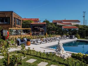 a pool with chairs and a statue in front of a house at Villas Pomar do Moinho in Usseira