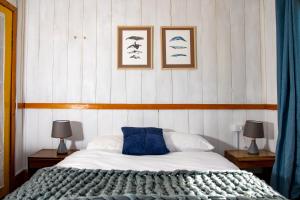 sypialnia z łóżkiem i 2 zdjęciami na ścianie w obiekcie La Casa de Alerce w mieście Chacao