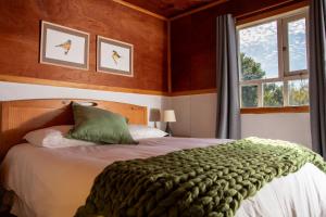 sypialnia z łóżkiem z zielonym kocem w obiekcie La Casa de Alerce w mieście Chacao