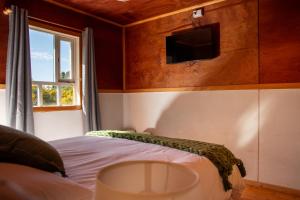 a bedroom with a bed and a tv on the wall at La Casa de Alerce in Chacao