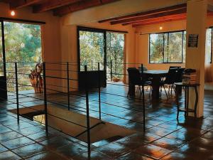 una sala da pranzo con tavolo, sedie e finestre di CASA LOS OCOTES VALLE DE BRAVO EDO MEX a Valle de Bravo