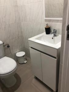 a white bathroom with a toilet and a sink at Apartamento Da Costa in Mão para Trás +14 photos