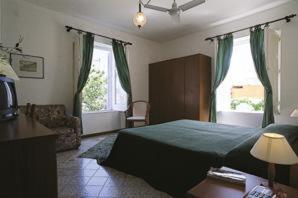a bedroom with a bed and a window at Hotel Villa Augustus in Lipari