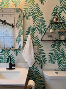 a bathroom with green palm leaves wallpaper at Sunshine House in Reno