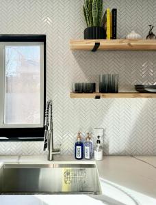 um lavatório de cozinha com duas garrafas de sabão e uma janela em Sunshine House em Reno