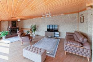 sala de estar con sofás de cuero y TV en Spacious Duplex With Stunning Halic Views en Estambul