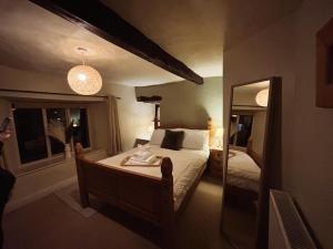 a hotel room with a bed and a mirror at Holly Cottage in Cartmel