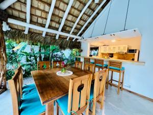 uma sala de jantar com uma mesa de madeira e cadeiras em Maloca by Villa Clarissa8 em Las Terrenas