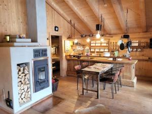 eine große Küche mit einem Tisch und einem Kamin in der Unterkunft Casa Royal - Schönes Blockhaus mit Außensauna und Bade-Bottich in Sankt Englmar