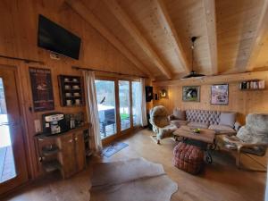 uma sala de estar com um sofá e uma mesa em Casa Royal - Schönes Blockhaus mit Außensauna und Bade-Bottich em Sankt Englmar