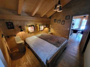 ein Schlafzimmer mit einem großen Bett in einem Holzzimmer in der Unterkunft Casa Royal - Schönes Blockhaus mit Außensauna und Bade-Bottich in Sankt Englmar