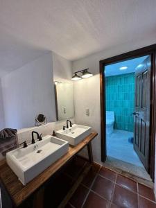 ein Badezimmer mit zwei Waschbecken, einem WC und einem Spiegel in der Unterkunft Comodidad y diseño cerca del pueblo in Mazamitla