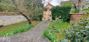 a garden with a pathway leading to a house at COQUELICOT - Spacieuse maison 172m2 - 4 chambres - Parking Privé & Wifi Gratuit in Brunoy