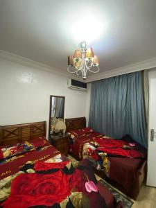a bedroom with two beds and a chandelier at gleem alexandria in Alexandria