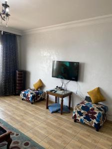a living room with a flat screen tv on the wall at gleem alexandria in Alexandria