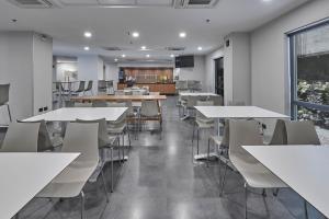 a dining room with white tables and chairs at City Express by Marriott Queretaro in Quer&eacute;taro