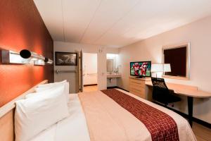 a hotel room with a bed and a desk at Red Roof Inn Chicago - Joliet in Joliet