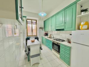 a green kitchen with a table and a refrigerator at Begonie House in Rome