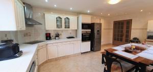 a kitchen with white cabinets and a table in it at COQUELICOT - Spacieuse maison 172m2 - 4 chambres - Parking Privé & Wifi Gratuit in Brunoy