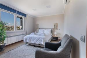 1 dormitorio con 1 cama, 2 sillas y ventana en 2 Br W Panoramic Bosphorus Views & Cleaning, en Estambul