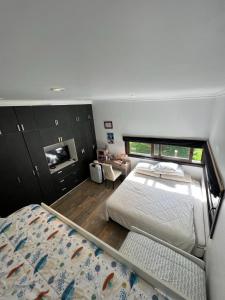 a bedroom with a bed and a tv in it at Casa de campo in Valdivia