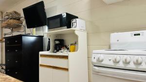 a kitchen with a microwave and a stove at Travellers Motel in Cranbrook