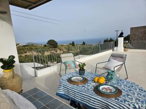 a table with plates of food on a balcony at Villa Margot in Lipari