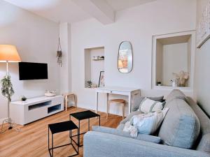 een woonkamer met een blauwe bank en een tv bij Oasis Parfumée 4 couchages in Grasse