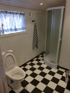 a bathroom with a toilet and a black and white checkered floor at Pålgarden in Ørsta