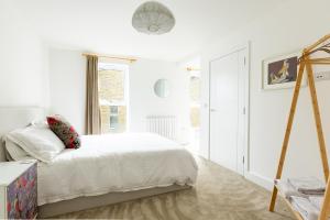 ein weißes Schlafzimmer mit einem Bett und einem Fenster in der Unterkunft PAPER MILL - Experience the city and nature side of this stay! in Sheffield