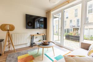 ein Wohnzimmer mit einem großen Fenster und einem TV in der Unterkunft PAPER MILL - Experience the city and nature side of this stay! in Sheffield