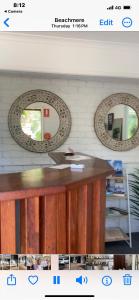 a website with two mirrors on a wall at Beachmere Palms Motel in Beachmere