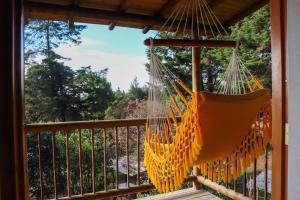 a hammock on the porch of a house at Casa Profunda - Santa Elena in Medellín