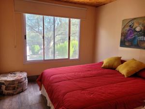 a bedroom with a large red bed and a window at CASA PARA 10 PERSONAS, CAFAYATE in Cafayate
