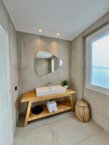 a bathroom with a sink and a mirror at Sofos Suites Mykonos in Mikonos
