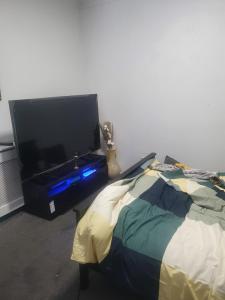 a flat screen tv sitting next to a bed at Queensgate centre in Stifford