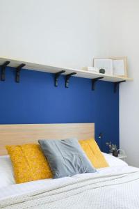 eine blaue Wand mit einem Regal über einem Bett in der Unterkunft Beautiful cozy apartment for 2 people in Prag