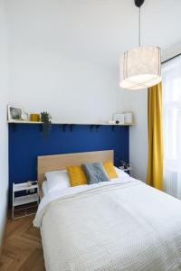 ein Schlafzimmer mit einem großen Bett mit blauer Wand in der Unterkunft Beautiful cozy apartment for 2 people in Prag