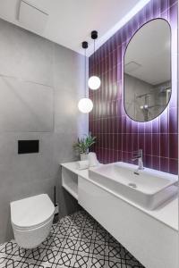 ein Badezimmer mit einem WC, einem Waschbecken und einem Spiegel in der Unterkunft Beautiful cozy apartment for 2 people in Prag
