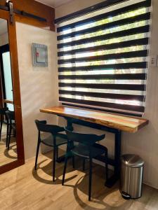 a table and two chairs in front of a window at Cozy Tiny Home with Outdoor Hot Tub in City Center in Davao City
