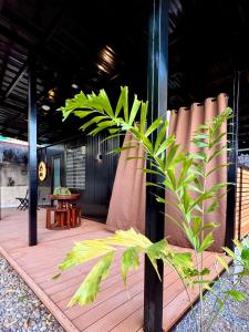 a wooden deck with a table and a plant at Cozy Tiny Home with Outdoor Hot Tub in City Center in Davao City